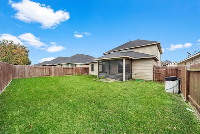 rear view of property featuring a sunroom and a yard