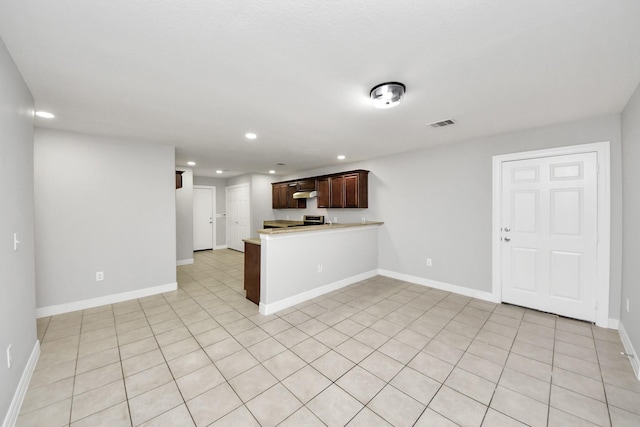 kitchen with stainless steel stove, kitchen peninsula, and light tile patterned flooring