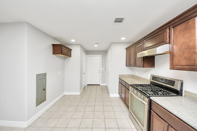 kitchen with stainless steel gas range oven and light tile patterned floors