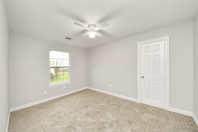 carpeted spare room featuring ceiling fan