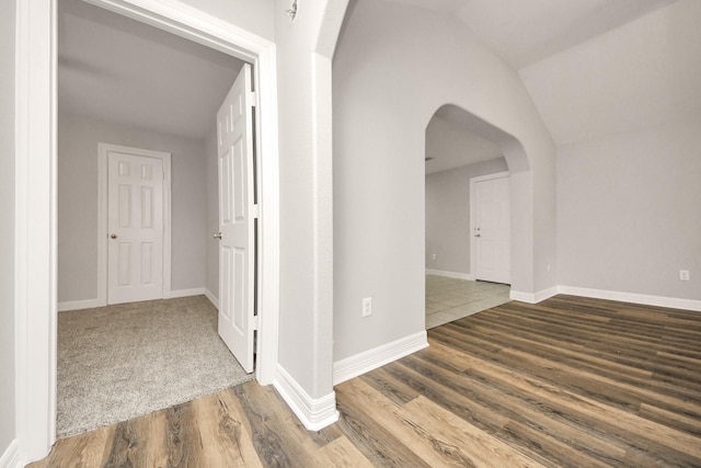 hall with hardwood / wood-style flooring and lofted ceiling