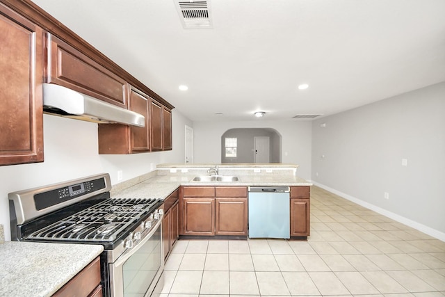 kitchen featuring light tile patterned flooring, stainless steel appliances, kitchen peninsula, and sink