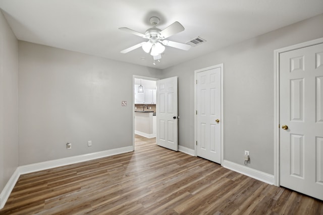 unfurnished bedroom featuring hardwood / wood-style floors and ceiling fan