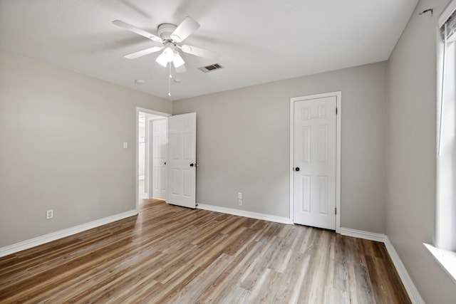 empty room with ceiling fan and light hardwood / wood-style floors