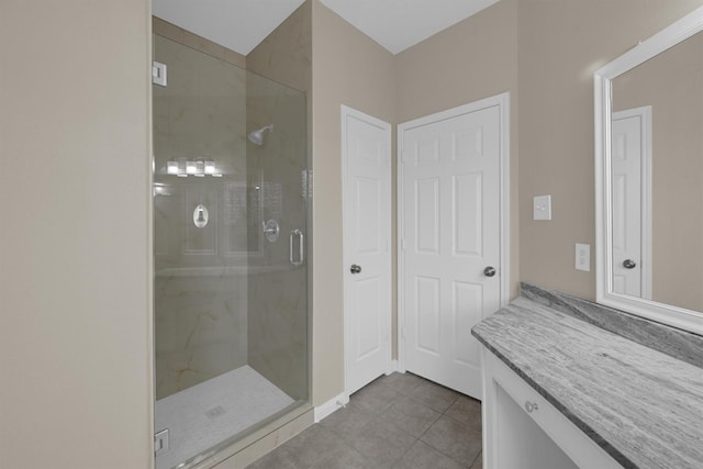 bathroom with walk in shower, vanity, and tile patterned flooring