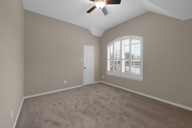 spare room with ceiling fan, lofted ceiling, and light carpet