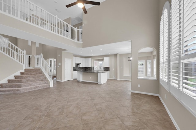 unfurnished living room featuring ceiling fan and light tile patterned floors