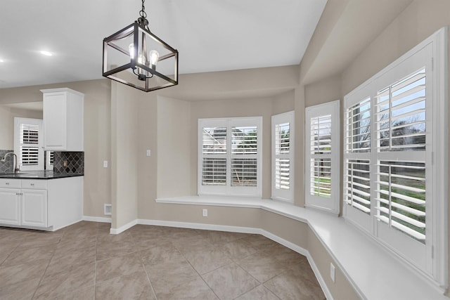 unfurnished dining area with an inviting chandelier, sink, and light tile patterned floors