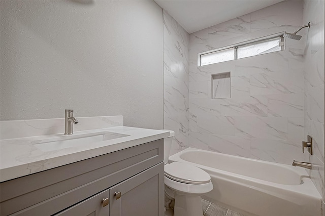 full bathroom featuring vanity, tiled shower / bath combo, and toilet