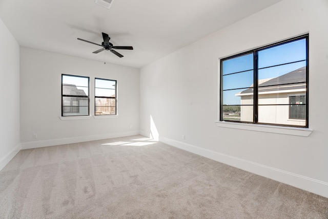 spare room featuring light colored carpet and ceiling fan