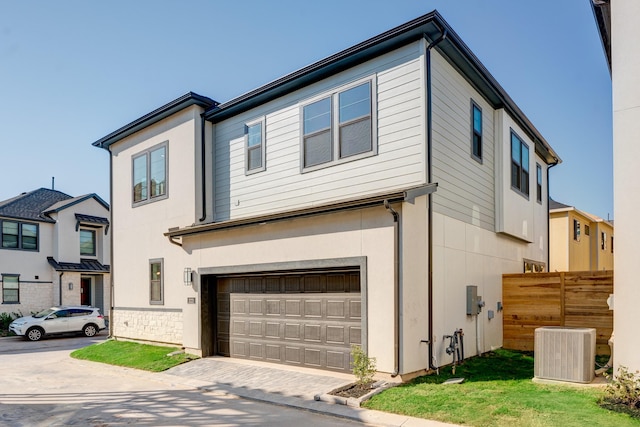 view of front of property with a garage and central air condition unit