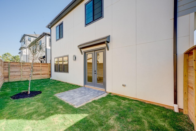 back of house featuring a lawn, french doors, and a patio area