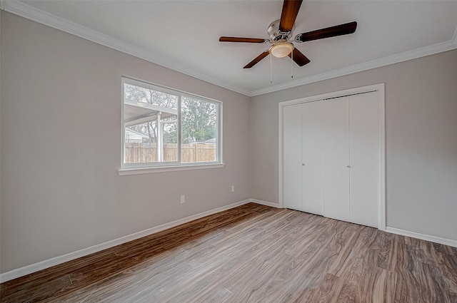 unfurnished bedroom with crown molding, ceiling fan, light hardwood / wood-style floors, and a closet