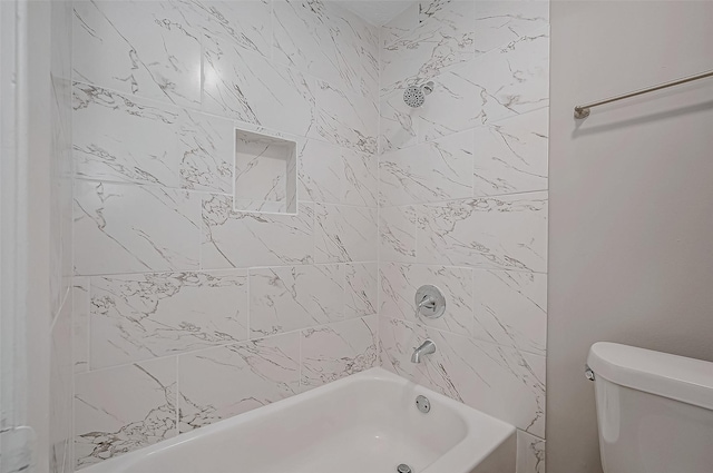 bathroom with tiled shower / bath combo and toilet