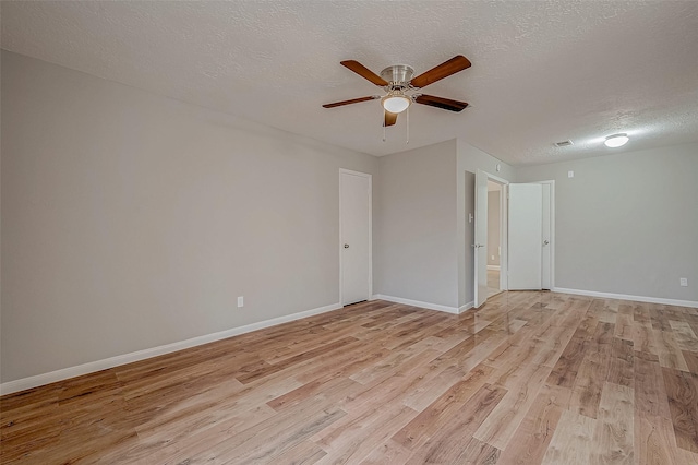 unfurnished room with ceiling fan, a textured ceiling, and light wood-type flooring