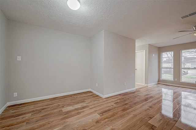 unfurnished room featuring a textured ceiling, light hardwood / wood-style flooring, and ceiling fan