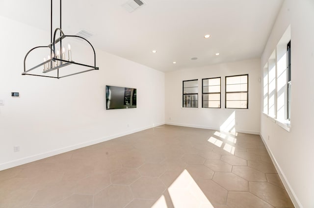 unfurnished living room featuring a notable chandelier and light tile patterned flooring