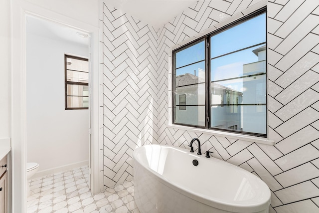 bathroom with tile walls, a washtub, and toilet