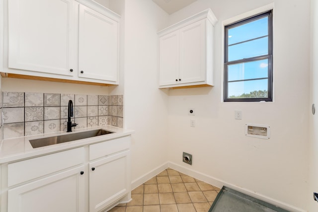 laundry room featuring light tile patterned flooring, sink, cabinets, washer hookup, and electric dryer hookup