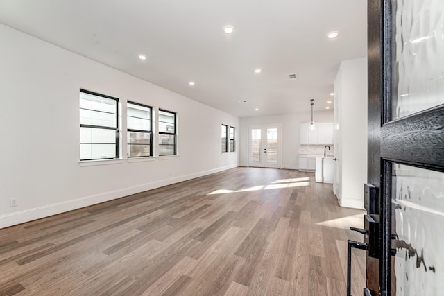 unfurnished living room featuring sink and light wood-type flooring