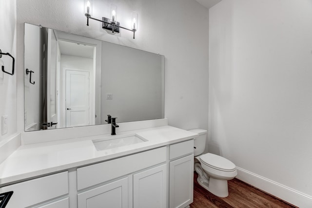 bathroom with hardwood / wood-style flooring, vanity, and toilet