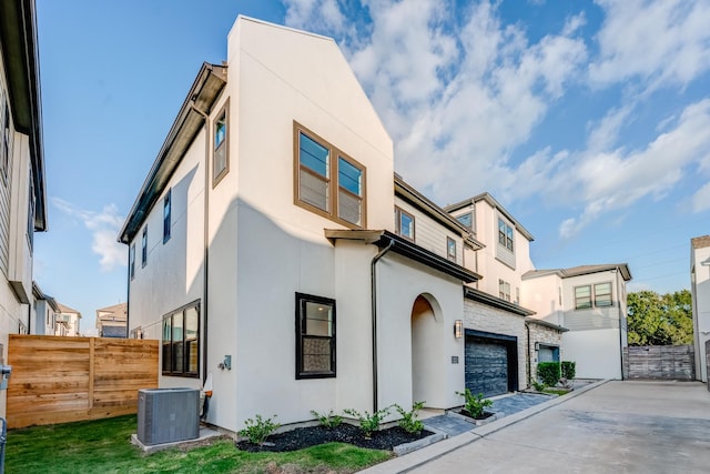 view of front of home with a garage and central AC unit