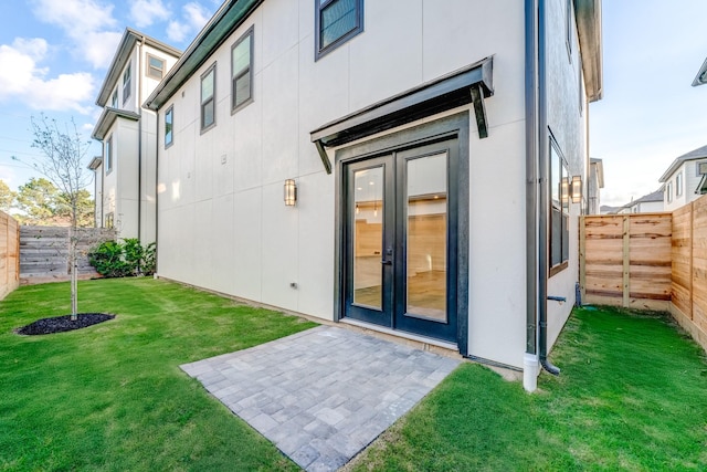 rear view of house with french doors, a yard, and a patio area