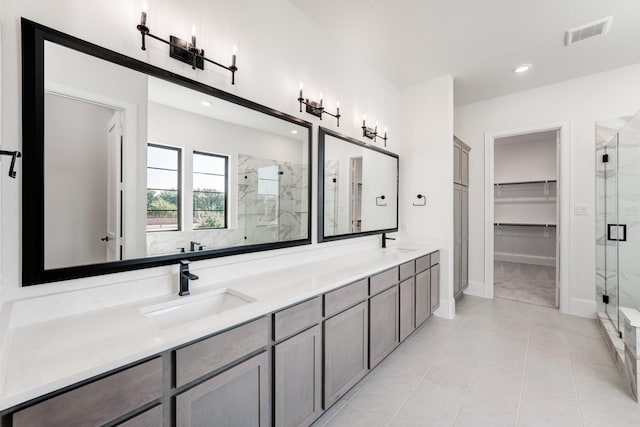 bathroom featuring tile patterned flooring, vanity, and a shower with shower door