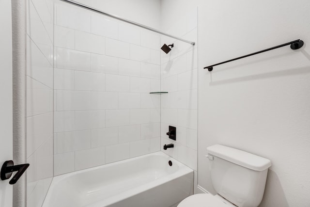 bathroom featuring tiled shower / bath and toilet