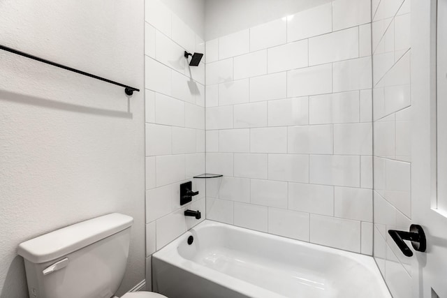 bathroom featuring tiled shower / bath and toilet