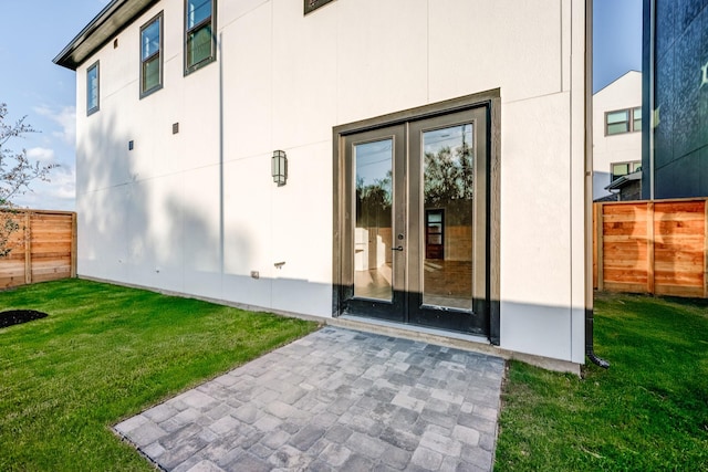 entrance to property featuring a lawn and french doors