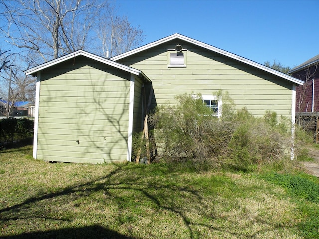 view of side of home with a lawn