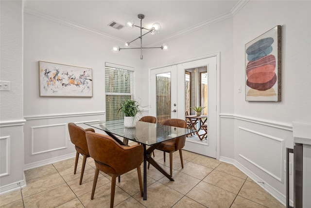 dining space with ornamental molding, light tile patterned flooring, a chandelier, and french doors