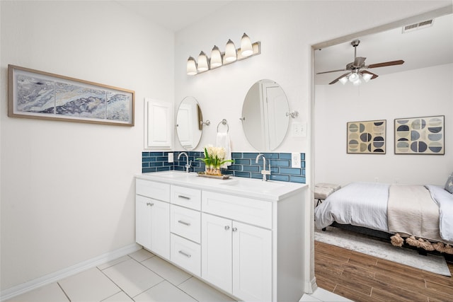 bathroom with ceiling fan, vanity, wood-type flooring, and backsplash