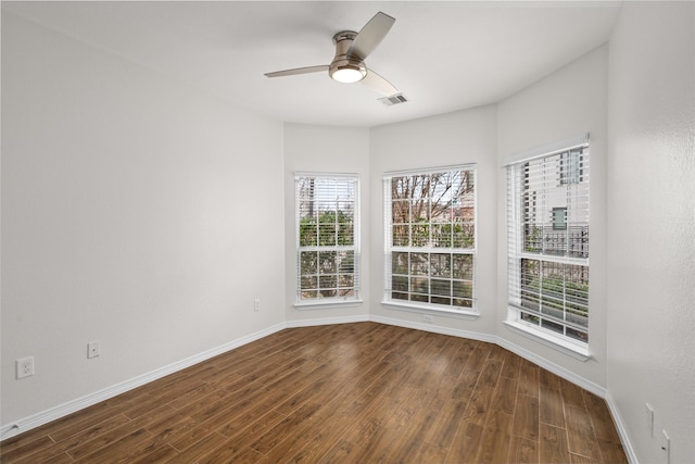 spare room with dark wood-type flooring and ceiling fan