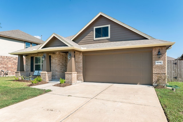 view of front of property with a garage, a front yard, and covered porch