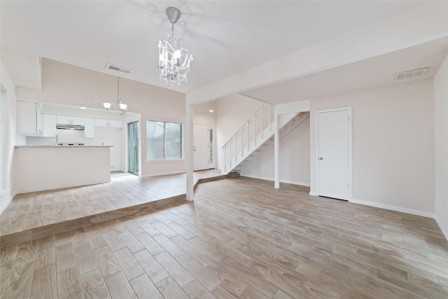 unfurnished living room featuring an inviting chandelier