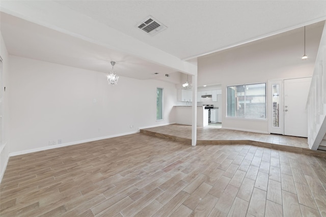 unfurnished living room with an inviting chandelier