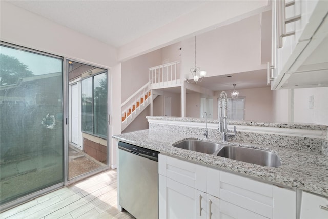 kitchen featuring white cabinets, decorative light fixtures, sink, and dishwasher