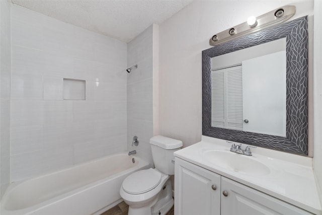 full bathroom featuring vanity, bathtub / shower combination, a textured ceiling, and toilet