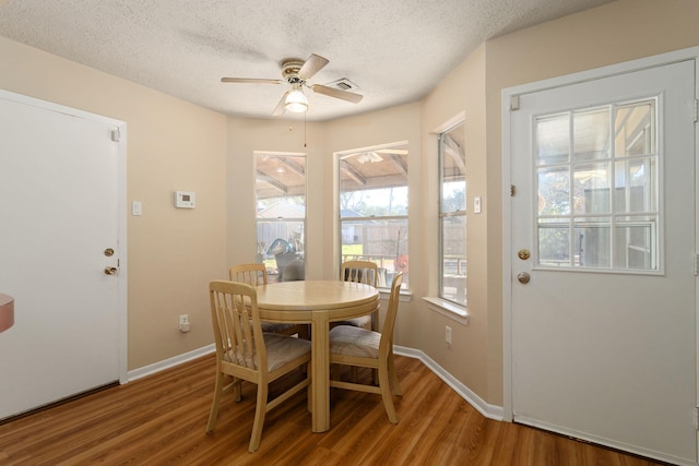 dining area featuring hardwood / wood-style flooring, ceiling fan, and a textured ceiling