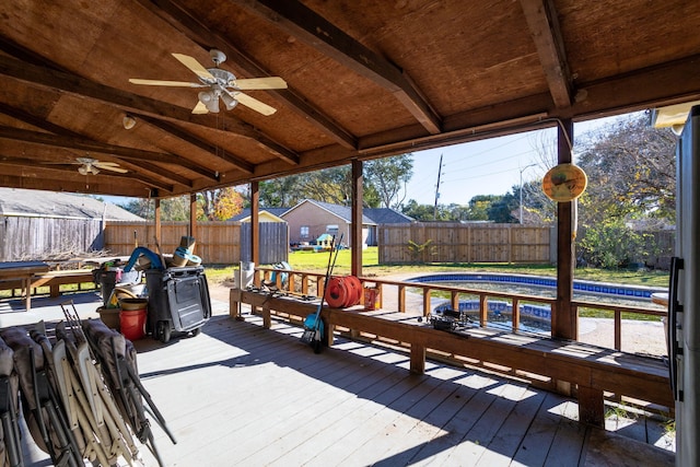 wooden deck with a pool and ceiling fan