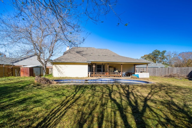 rear view of property with a lawn and a storage shed