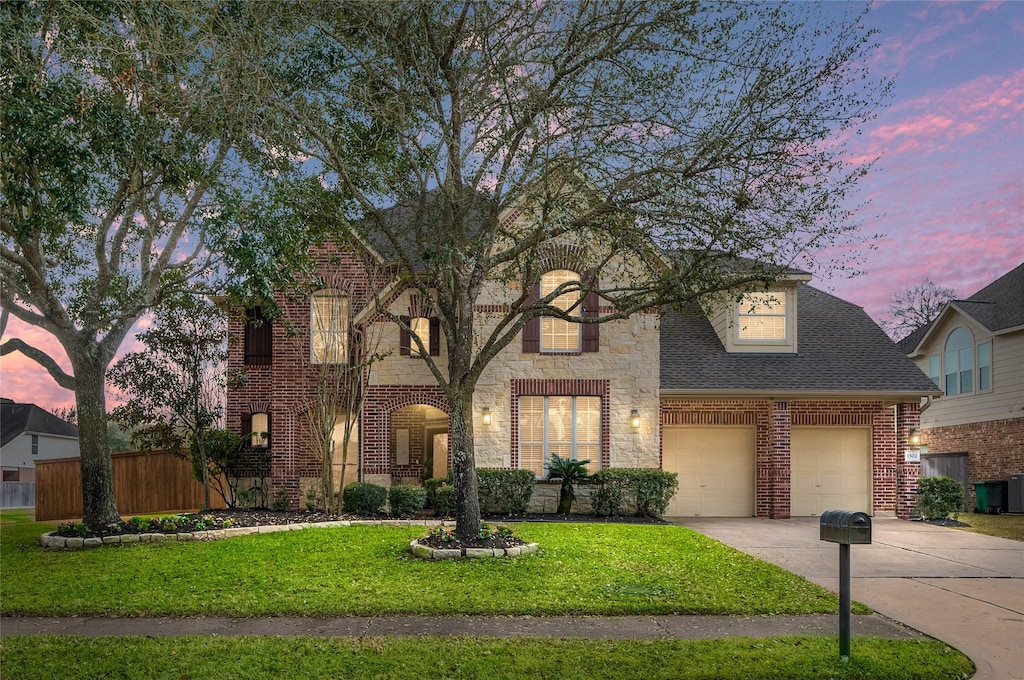 view of front of property with a garage and a lawn