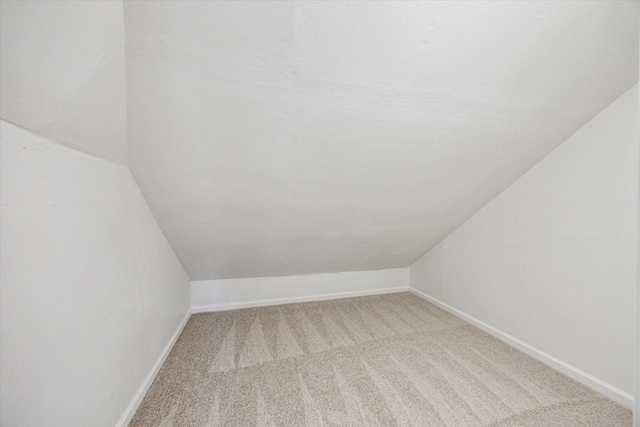 interior space featuring vaulted ceiling and carpet