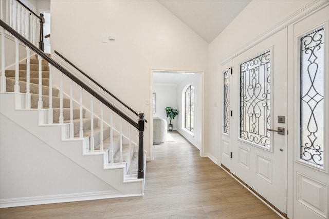 entrance foyer with high vaulted ceiling and light wood-type flooring