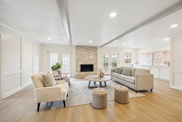 living room featuring french doors, light wood-type flooring, and a wealth of natural light