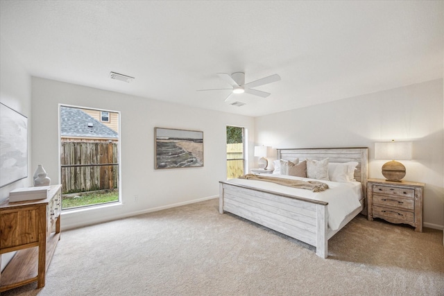 carpeted bedroom with ceiling fan and multiple windows