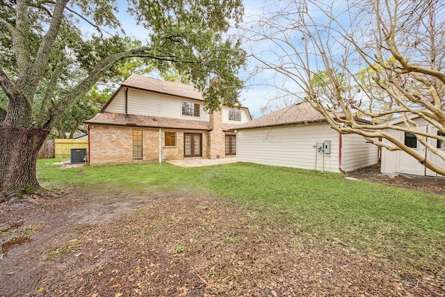 rear view of house with a yard and cooling unit