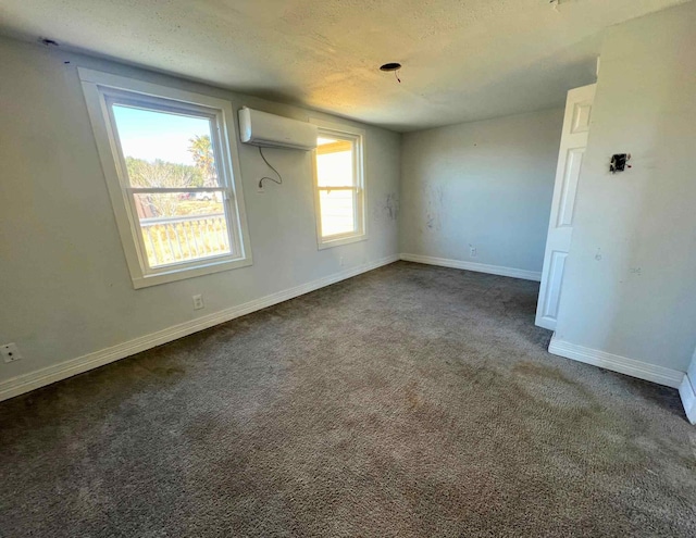 carpeted empty room featuring a wall mounted AC and a textured ceiling